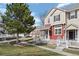 Inviting townhome exterior with a mature shade tree and charming white picket fence at 1479 Nemrick Pl, Castle Rock, CO 80109
