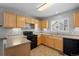 Kitchen with light wood cabinets and black appliances at 1479 Nemrick Pl, Castle Rock, CO 80109
