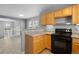 Kitchen with light wood cabinets, black appliances, and tiled floors at 1479 Nemrick Pl, Castle Rock, CO 80109