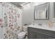 Updated bathroom featuring a new vanity, stylish mirror, and floral shower curtain at 6452 Freeport Dr, Highlands Ranch, CO 80130