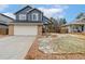 Charming two-story home featuring a blue exterior, brick accents, and a well-maintained front yard at 6452 Freeport Dr, Highlands Ranch, CO 80130