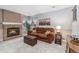 Cozy living room with a brick fireplace, plush seating, and carpeted floors at 6452 Freeport Dr, Highlands Ranch, CO 80130