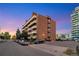 Multi-story brick building with balconies and ample parking in a vibrant urban setting at 4110 Hale Parkway Pkwy # 3J, Denver, CO 80220
