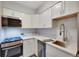 Updated kitchen with white cabinets, stainless steel appliances, quartz countertops, and modern fixtures at 4110 Hale Parkway Pkwy # 3J, Denver, CO 80220