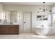 Modern bathroom featuring a soaking tub, wood vanity, and contemporary lighting fixtures at 2778 Utica St, Denver, CO 80212