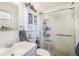Bright bathroom with a frosted glass shower, white sink, and built-in cabinet storage at 7780 S Kendall Blvd, Littleton, CO 80128
