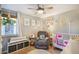 Comfortable Bedroom featuring a modern ceiling fan and a cozy, upholstered glider at 7780 S Kendall Blvd, Littleton, CO 80128