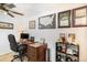 Study room with a wood desk, leather office chair, and wall décor with academic regalia at 7780 S Kendall Blvd, Littleton, CO 80128