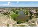 Aerial view of a community with a pond, walking paths, and scenic landscaping amid residential homes at 655 Tiger Lily Way, Highlands Ranch, CO 80126