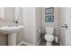 Stylish powder room features a modern pedestal sink and tiled floor at 655 Tiger Lily Way, Highlands Ranch, CO 80126