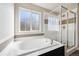 Luxurious bathroom featuring a soaking tub and a separate glass-enclosed shower at 655 Tiger Lily Way, Highlands Ranch, CO 80126