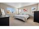 Sunny bedroom showcasing large windows with neighborhood views and a comfortable bed at 655 Tiger Lily Way, Highlands Ranch, CO 80126