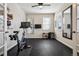 Bright exercise room with gym equipment, mirror, ceiling fan, ample natural light, and black rubberized flooring at 655 Tiger Lily Way, Highlands Ranch, CO 80126