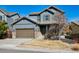 Charming two-story home featuring stone accents, a covered porch, and a well-maintained front yard in a suburban neighborhood at 655 Tiger Lily Way, Highlands Ranch, CO 80126