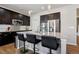 Kitchen island with dark cabinets, granite countertops, stainless steel appliances, tile backsplash, hardwood floors, and breakfast bar seating at 655 Tiger Lily Way, Highlands Ranch, CO 80126