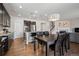 Open-concept kitchen with dark wood cabinets, granite island, stainless appliances, hardwood floors, and adjacent living area with fireplace at 655 Tiger Lily Way, Highlands Ranch, CO 80126