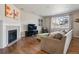 Cozy living room features a fireplace, hardwood floors, and neutral-toned furnishings at 655 Tiger Lily Way, Highlands Ranch, CO 80126