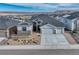 Charming exterior with three-car garage, gravel landscaping, and mountain view in the distance at 815 Alumroot St, Castle Rock, CO 80104