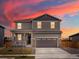 Charming two-story home with stone accents, covered porch, and a two-car garage at sunset at 8840 Sedalia St, Commerce City, CO 80022