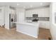 Modern kitchen featuring white cabinets, stainless steel appliances, and a large center island at 8840 Sedalia St, Commerce City, CO 80022