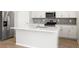 Modern kitchen featuring white cabinets, stainless steel appliances, and a large center island at 8840 Sedalia St, Commerce City, CO 80022