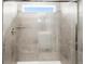 Modern tiled shower with glass enclosure and a transom window at 8840 Sedalia St, Commerce City, CO 80022
