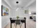 Contemporary dining area with a black table, chairs, and stylish pendant lighting at 11985 E Harvard Ave # 108, Aurora, CO 80014