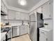 Well-lit kitchen with white cabinets, quartz countertops, and stainless steel appliances at 11985 E Harvard Ave # 108, Aurora, CO 80014