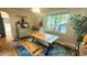 Well-lit dining room with a farmhouse style table and bench at 1303 Newport St, Denver, CO 80220