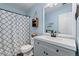 A well-lit bathroom features a decorative shower curtain, framed mirror, and storage for a functional space at 22142 E Belleview Place, Aurora, CO 80015