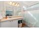 Bright bathroom with white cabinets, a large mirror, and a shower-tub combo at 22142 E Belleview Place, Aurora, CO 80015
