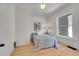 Sunlit bedroom showcasing hardwood floors, neutral walls, and a comfortable bed by a bright window at 169 W Byers Pl, Denver, CO 80223