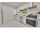 Bright kitchen featuring stainless steel appliances, white cabinetry and modern countertops, plus stylish floating shelves at 169 W Byers Pl, Denver, CO 80223