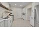 Bright kitchen featuring stainless steel appliances, white cabinetry and modern countertops, plus stylish floating shelves at 169 W Byers Pl, Denver, CO 80223