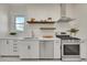 Modern kitchen with stainless steel appliances, granite countertops and floating wood shelves at 169 W Byers Pl, Denver, CO 80223