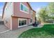 This backyard offers a cozy patio seating area, lush green lawn, and mature trees at 11373 Kearney Way, Thornton, CO 80233
