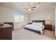Spacious bedroom featuring a ceiling fan, large window, and a comfortable bed with bedside tables at 11373 Kearney Way, Thornton, CO 80233