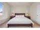 Well-lit bedroom showcasing a queen-size bed with decorative lamps on the nightstands, complemented by neutral tones at 11373 Kearney Way, Thornton, CO 80233