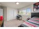 Bedroom with desk, a twin bed with comic-themed decor, a closet with sliding doors, and a large window at 11373 Kearney Way, Thornton, CO 80233