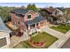 Exterior view of a charming two-story home with a brick-accented porch and well-maintained landscaping at 11373 Kearney Way, Thornton, CO 80233
