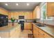 Functional kitchen with light wood cabinets, black appliances, and a central island for food prep at 11373 Kearney Way, Thornton, CO 80233