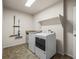 Functional laundry room with modern appliances, storage shelf, and neutral walls at 11373 Kearney Way, Thornton, CO 80233