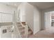 Carpeted staircase with white banister leading to the upper level of the home, showing a light-filled landing at 11373 Kearney Way, Thornton, CO 80233