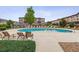 Large community pool with lounge chairs and manicured landscaping set against a backdrop of well-maintained buildings at 1466 Turnberry Dr, Castle Rock, CO 80104