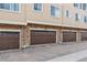 Townhome exterior features three brown garage doors framed by stone pillars and siding, each marked with unit numbers at 1466 Turnberry Dr, Castle Rock, CO 80104