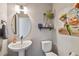 Stylish powder room featuring a pedestal sink, decorative mirror, and modern fixtures at 6737 S Tempe Ct, Aurora, CO 80016