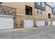 Row of garages for townhome residences, each with unique exterior finishes at 6737 S Tempe Ct, Aurora, CO 80016