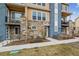 Close up of a well-maintained, modern townhome exterior featuring stone accents and manicured landscaping at 6737 S Tempe Ct, Aurora, CO 80016