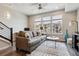 Bright living room featuring a comfortable sofa, a patterned rug, and large windows at 6737 S Tempe Ct, Aurora, CO 80016
