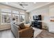 Inviting living area featuring a plush sofa, sleek entertainment center, and bright windows with neighborhood views at 6737 S Tempe Ct, Aurora, CO 80016